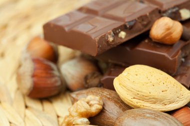 Bar of chocolate and nuts on a wicker mat