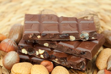 Bar of chocolate and nuts on a wicker mat