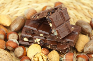 Bar of chocolate and nuts on a wicker mat