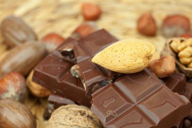 Bar of chocolate and nuts on a wicker mat