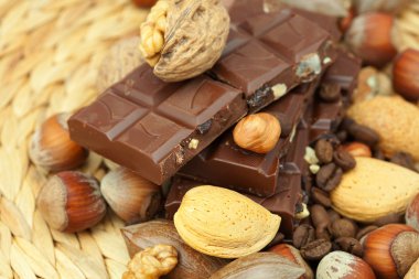 Bar of chocolate and nuts on a wicker mat