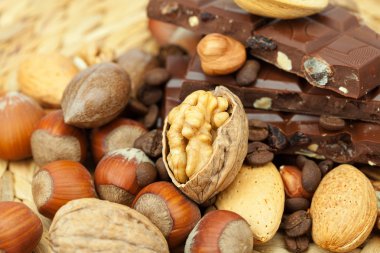 Bar of chocolate and nuts on a wicker mat