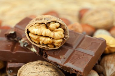 Bar of chocolate and nuts on a wicker mat