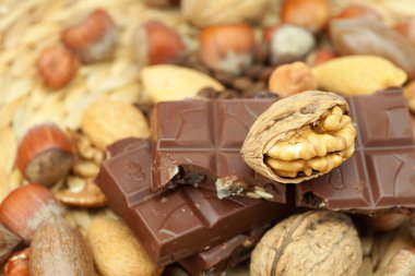 Bar of chocolate and nuts on a wicker mat