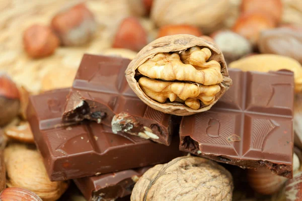 Bar of chocolate and nuts on a wicker mat