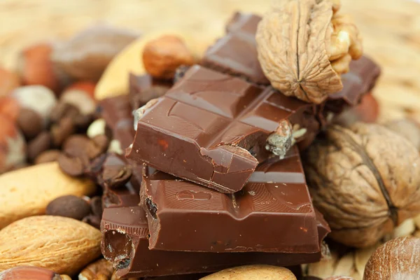 Barra de chocolate y nueces en una estera de mimbre —  Fotos de Stock