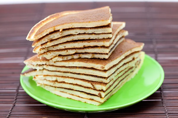 Pancakes on a plate on a bamboo mat — Stock Photo, Image