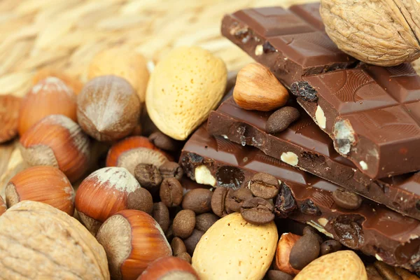 Barre de chocolat et de noix sur un tapis en osier — Photo
