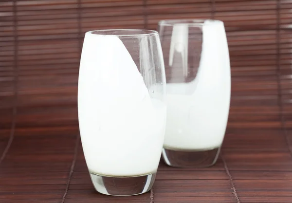 Dos vasos de leche en una estera de bambú —  Fotos de Stock
