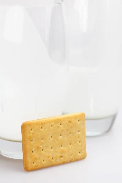 Dois copos de leite e biscoitos em um fundo cinza — Fotografia de Stock