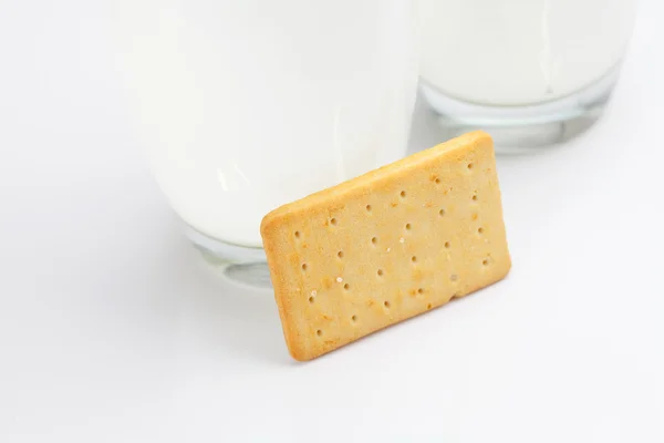 Dvě sklenice mléka a soubory cookie na šedém pozadí — Stock fotografie