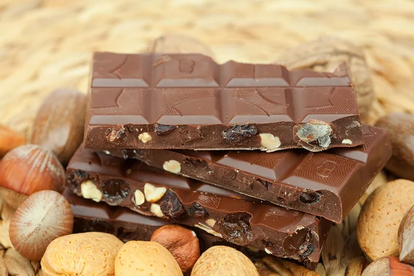 Barra de chocolate y nueces en una estera de mimbre — Foto de Stock