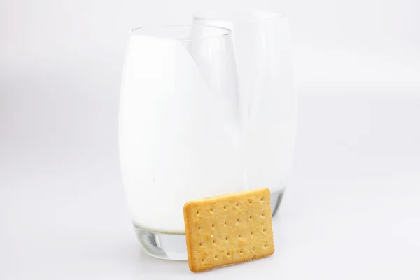 Twee glazen van melk en koekjes op een grijze achtergrond — Stockfoto