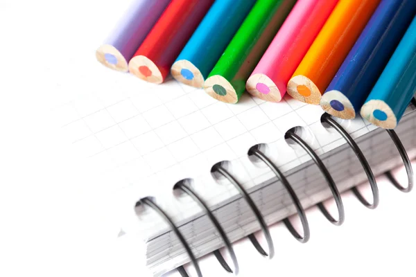 Renkli kalemler ve üzerinde beyaz izole bir defter — Stok fotoğraf