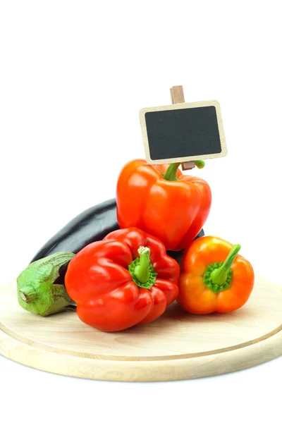 Stock image Red peppers, eggplant and board on a cutting board isolated on w