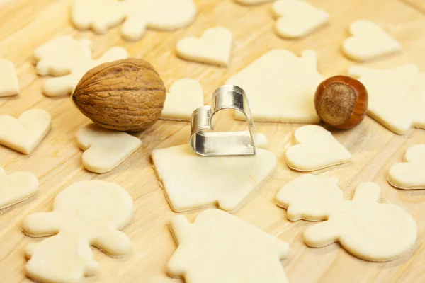Cortar massa boneco de neve, casa, nozes, coração e formas para os biscoitos — Fotografia de Stock