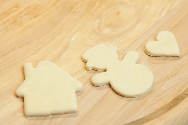 Cut in the dough snowman, heart, and house — Stock Photo, Image