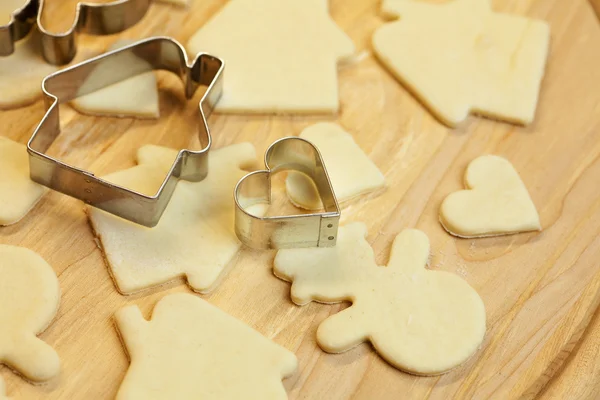 Зрізане тісто сніговик, будинок, серце і форми для печива — стокове фото