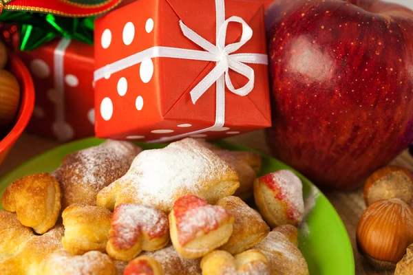 Plato, galletas, nueces, manzana, arcos, cajas, regalos, bolas de Navidad — Foto de Stock