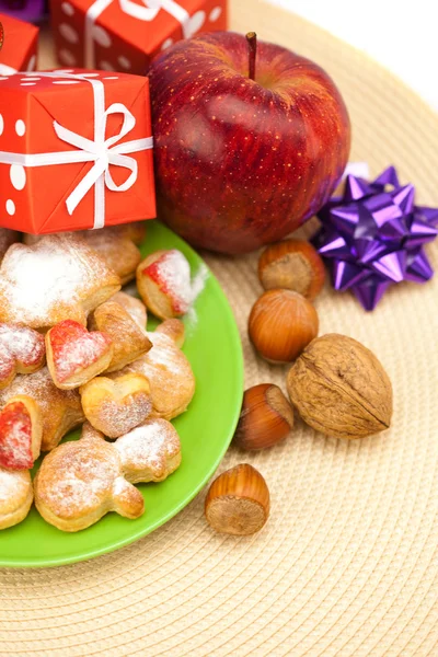 Dish, cookies, nuts, apple, bows, boxes, gifts, Christmas balls — Stock Photo, Image