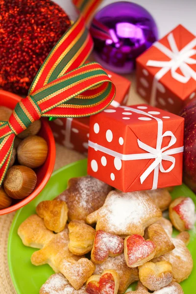 Plat, biscuits, noix, pomme, arcs, boîtes, cadeaux, boules de Noël — Photo