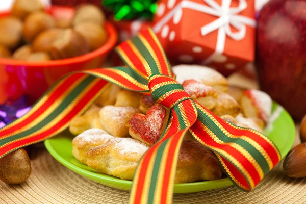 Prato, biscoitos, nozes, maçã, arcos, caixas, presentes, bolas de Natal — Fotografia de Stock