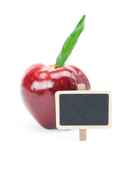 Красное яблоко с зеленым листом и доской, изолированной на белом — стоковое фото