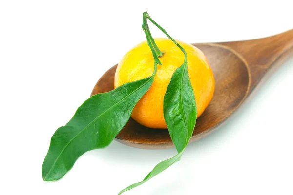 Mandarino con foglie verdi su un cucchiaio di legno isolato su bianco — Foto Stock