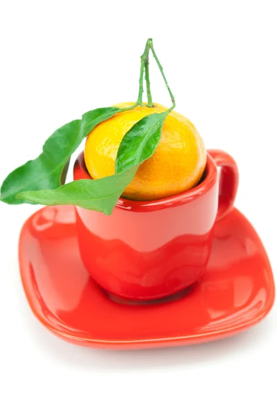 Mandarina con hojas verdes en una taza aislada en blanco — Foto de Stock