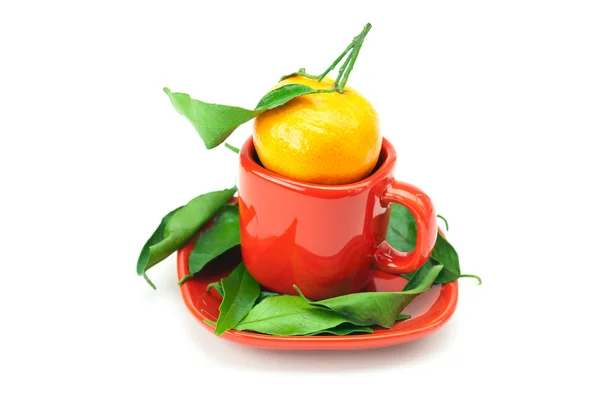Mandarino con foglie verdi in una tazza isolata su bianco — Foto Stock