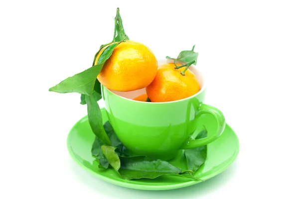 Mandarin with green leaves in a cup isolated on white — Stock Photo, Image