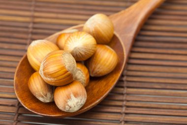 Bambu hasır üstünde tahta kaşık üzerine fındık