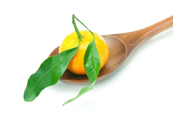 Mandarin med gröna blad på en träsked isolerad på vit — Stockfoto
