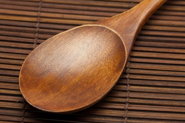 Wooden spoon on a bamboo mat — Stock Photo, Image