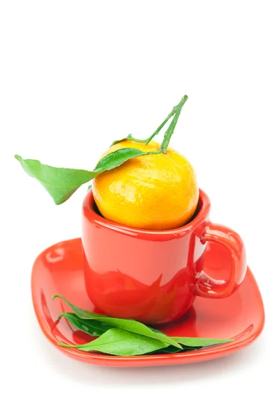 Mandarina con hojas verdes en una taza aislada en blanco — Foto de Stock