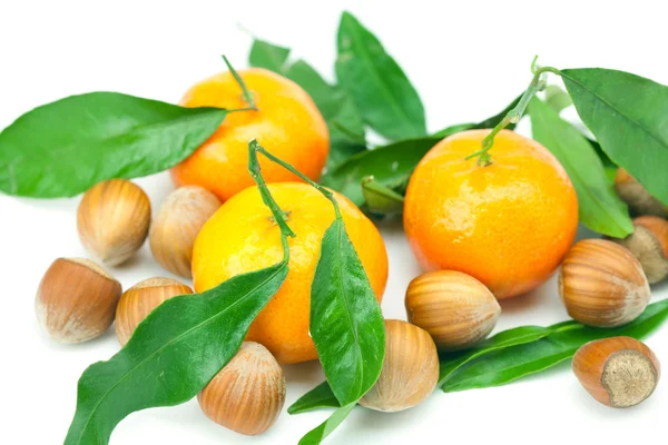 Mandarin with green leaves and nuts isolated on white — Stock Photo, Image