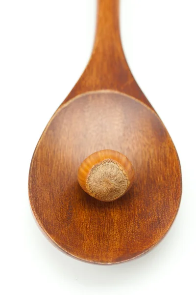 Φουντούκια σχετικά με ένα ξύλινο κουτάλι που απομονώνονται σε λευκό — Φωτογραφία Αρχείου