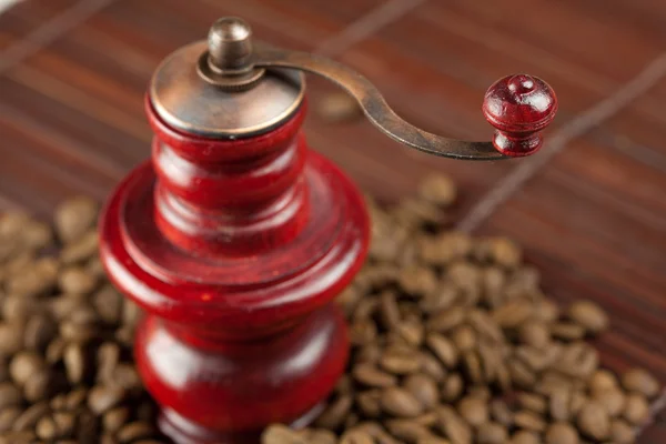 Kaffemølle og kaffebønner på bambusmåtte - Stock-foto