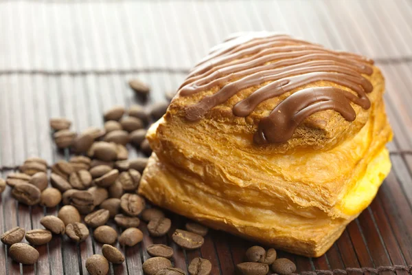 竹マットの上に横たわるチョコレートとコーヒーの豆のケーキ — ストック写真