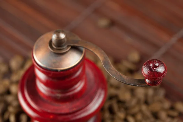 Mlýnek na kávu a kávové boby na bambusové rohoži — Stock fotografie
