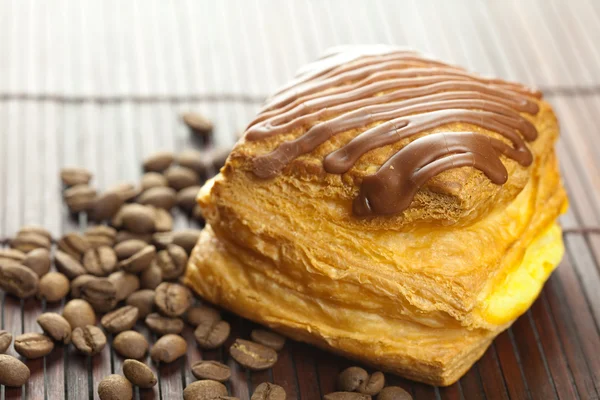 Kuchen mit Schokolade und Kaffeebohnen auf einer Bambusmatte liegend — Stockfoto