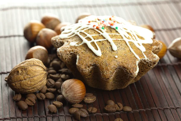 Kaka med glasyr, kaffebönor och nötter ligga på en bambu matta — Stockfoto