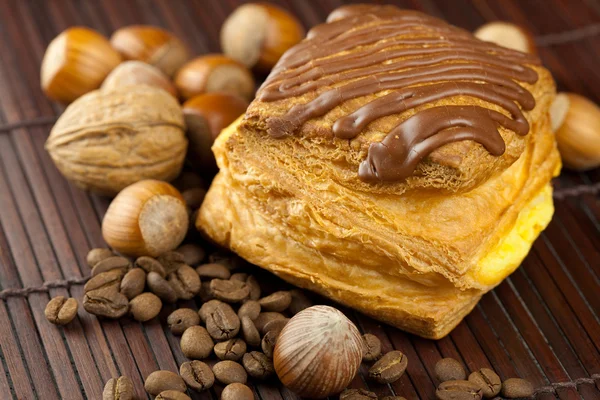 Çikolata, kahve çekirdeği ve bambu hasır üzerinde yalan fındık ile pasta — Stok fotoğraf