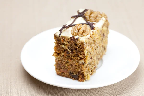 Piece of cake with nuts lying on the plate — Stock Photo, Image