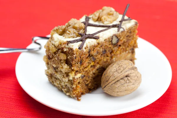 Pezzo di torta con noci e cucchiaio sdraiato su un piatto — Foto Stock