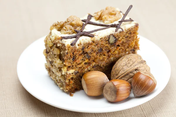 Pedazo de pastel con nueces acostadas en el plato — Foto de Stock