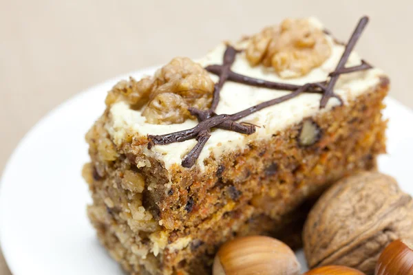 Pedazo de pastel con nueces acostadas en el plato — Foto de Stock