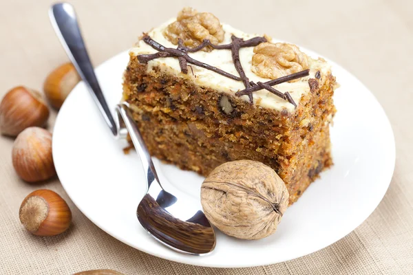 スプーン、プレートの上に横たわるとナッツのケーキ — ストック写真