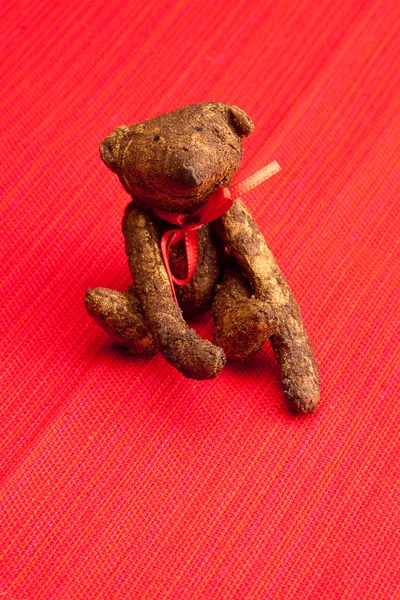 Kırmızı bir arka plan el yapımı oyuncak ayı — Stok fotoğraf