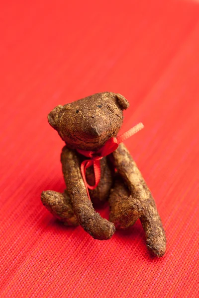 Kırmızı bir arka plan el yapımı oyuncak ayı — Stok fotoğraf